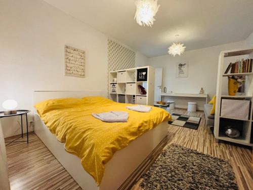 a bedroom with a large bed with a yellow blanket at Apartment city centrum in Nitra