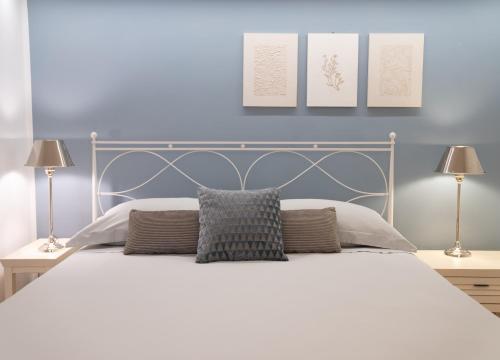 a bedroom with a white bed with two lamps at Il Torrione Relais in Sirolo