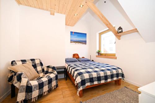 a bedroom with a bed and a chair at Apartamenty Poza Horyzont in Korbielów