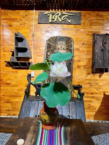 a vase with a flower sitting on a table at Pura homestay in Yên Minh