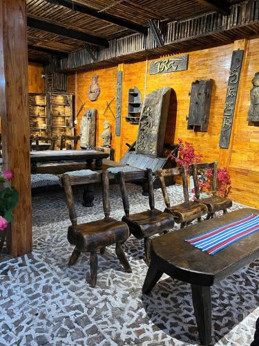 a room with a bench and chairs and a table at Pura homestay in Yên Minh
