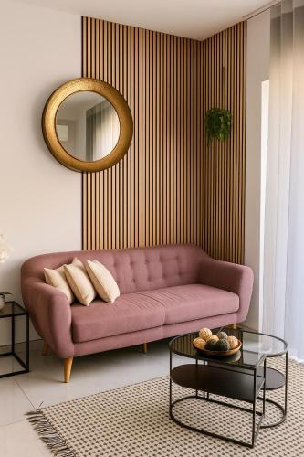 a living room with a pink couch and a mirror at Stylish 2-bedroom Apartment- near Valletta! Great for families or groups in Gwardamanġa