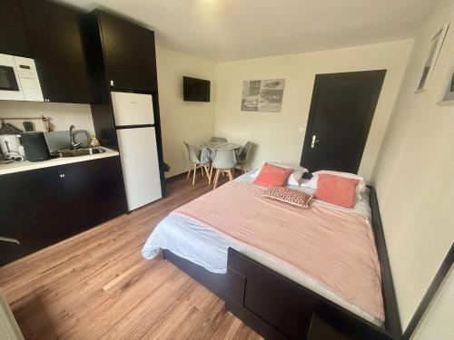 une chambre avec un grand lit et une cuisine dans l'établissement Escapade saint Michel, à Pontorson