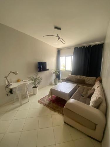 una sala de estar con un sofá y una mesa en Modern 2BR Apt RDC Fast Wi-Fi, en Cité Adrar