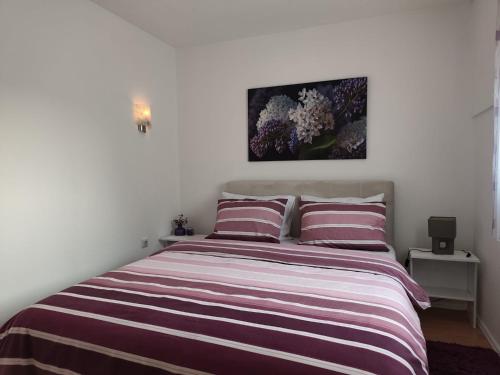 a bedroom with a bed with purple and white stripes at Apartment Lilac Sarajevo in Sarajevo