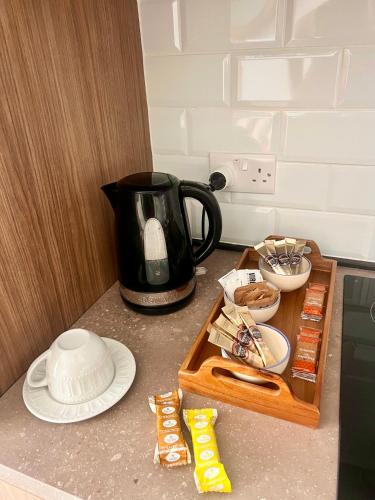 a counter with a coffee pot and a tray of food at Stylish 2-bedroom Apartment- near Valletta! Great for families or groups in Gwardamanġa