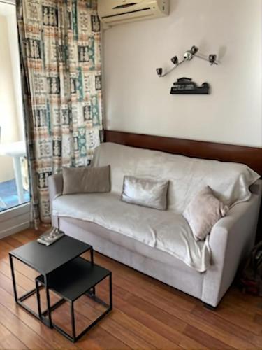 un canapé blanc dans un salon avec une table dans l'établissement Charming apartment 20 m from the beach in Arcachon, à Arcachon