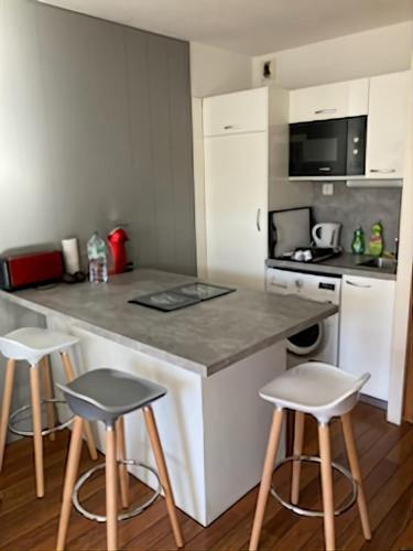 - une cuisine avec un comptoir et deux tabourets dans l'établissement Charming apartment 20 m from the beach in Arcachon, à Arcachon