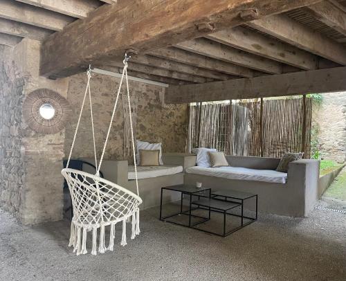 a porch with a couch and a swing at La Tuilerie du Bazalac in Trèbes