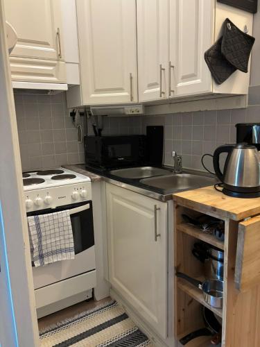 a kitchen with white cabinets and a sink at Central Studio in Vaasa with Free Parking in Vaasa