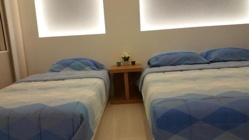 a bedroom with two beds and a wooden table at View Talay6 by Blue Ocean Suite in Pattaya Central