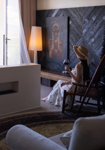 a woman sitting in a chair in a room at Lijiang Jijian Xiangwang SOOOAN Luxury Resort Hotel in Lijiang