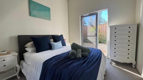 a bedroom with a bed and a dresser at Carlton 1910 Manly Hideaway in Sydney