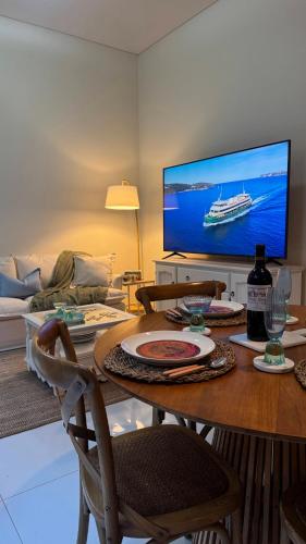 a living room with a table with a cruise ship on the screen at Carlton 1910 Manly Hideaway in Sydney