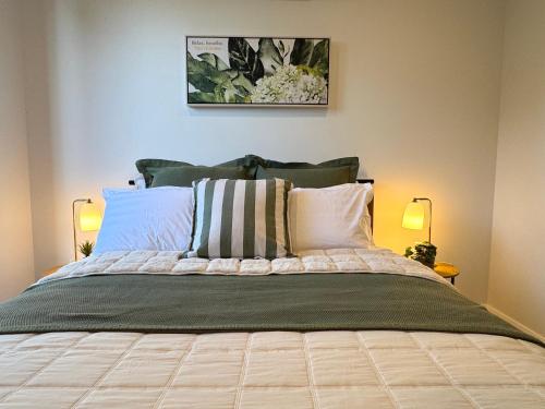 a bedroom with a large bed with two lamps at Luxe 2B2B Stay Walk to Sunnybank market square in Brisbane