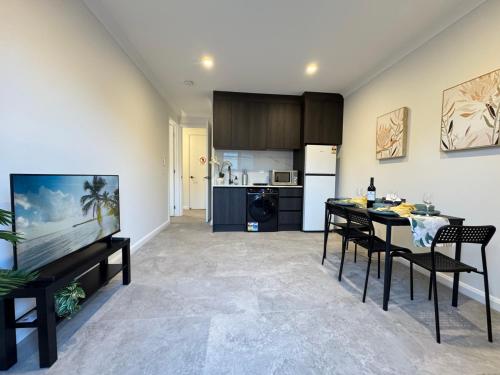 a kitchen and living room with a table and chairs at Luxe 2B2B Stay Walk to Sunnybank market square in Brisbane