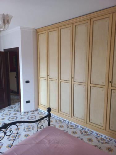 a bedroom with a bed and wooden cabinets at Villa Orchidea in Praia a Mare