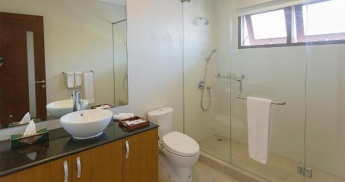 a bathroom with a toilet and a glass shower at Bali Diamond Estates & Villas in Keramas