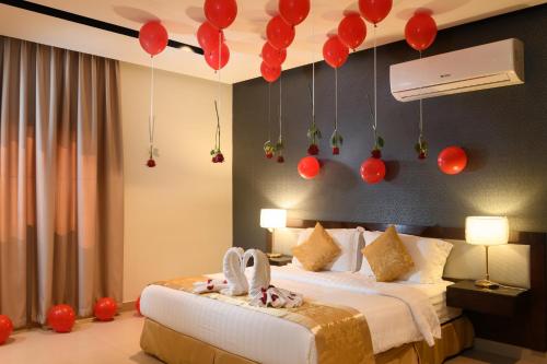 a bedroom with a bed with red balloons hanging from the ceiling at Triple Tree Serviced Unites in Al Hofuf