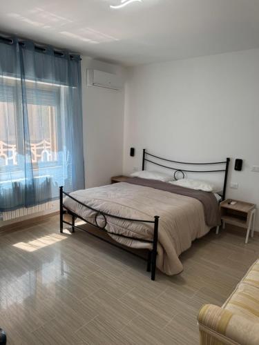 ein Schlafzimmer mit einem Bett und einem großen Fenster in der Unterkunft Stella di Mare in Montesilvano