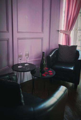 un salon avec deux tables et deux verres à vin dans l'établissement Suite Romantique La Charmante, à Villersexel