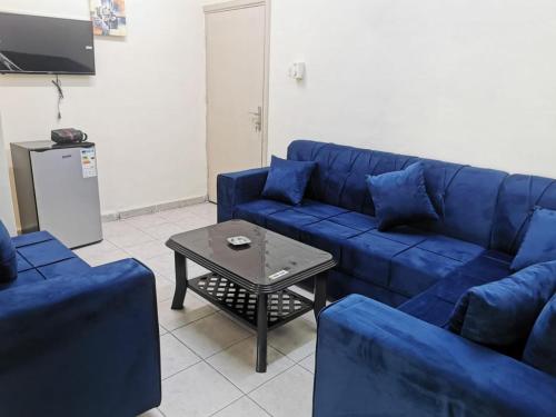 a living room with a blue couch and a table at Romero hotel apartments in Aqaba