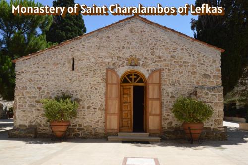 a small stone church with a door and two plants at Avlonari Evias flat in the Central Square in Avlonárion