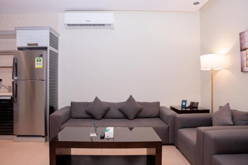 a living room with a couch and a refrigerator at Triple Tree Serviced Unites in Al Hofuf