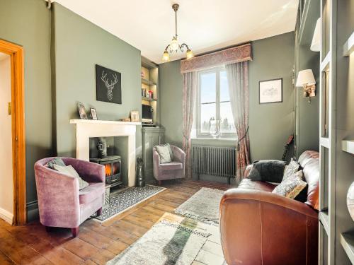 a living room with two chairs and a fireplace at Barleycombe in Loxton