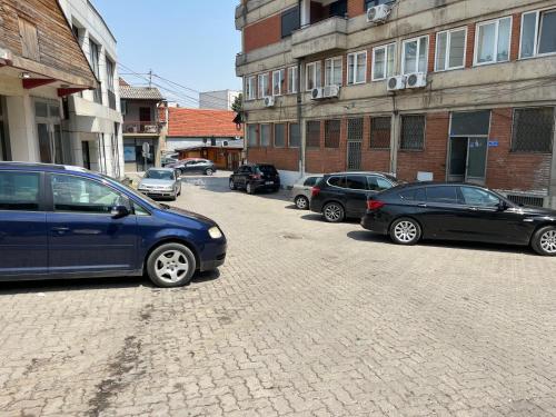 a group of parked cars parked on a brick street at Arbesi Apartament in Gjilan