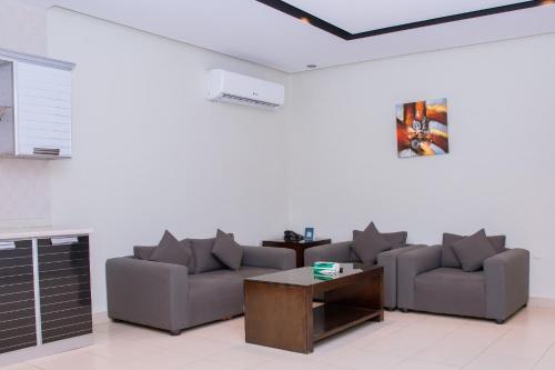 a living room with two couches and a coffee table at Triple Tree Serviced Unites in Al Hofuf