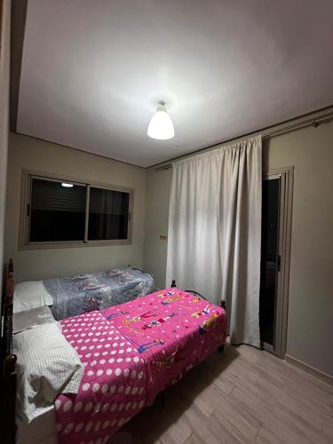 a bedroom with a pink bed and a window at Villa avec piscine in Meknès