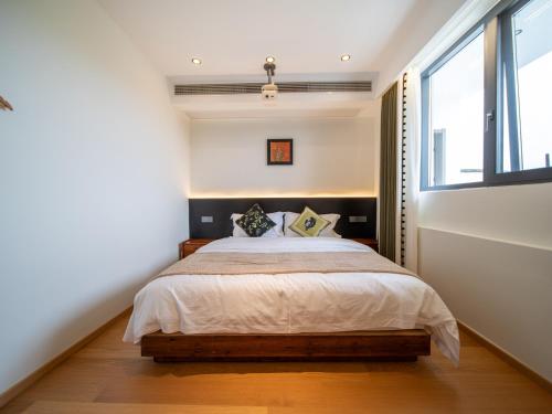 a bedroom with a bed and a large window at Huangshan Hongcun Weizhashan Xunxi Hotel in Huangshan