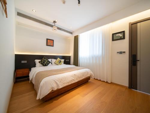 a bedroom with a large bed and a window at Huangshan Hongcun Weizhashan Xunxi Hotel in Huangshan