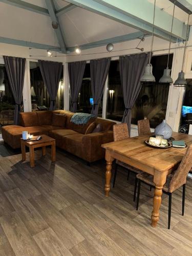 a living room with a couch and a table at Ferienhaus in Stavenisse mit Garten, Whirlpool und gemeinsamem Pool in Stavenisse