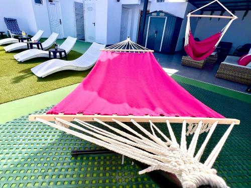 a hammock in a room with chairs and tables at Animoss! Apartments - 10 modern apartments near city center & beach in Santa Maria