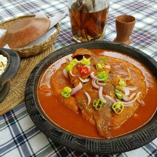 a bowl of soup with onions and peppers on a table at Hôtel Chez Jules 229 