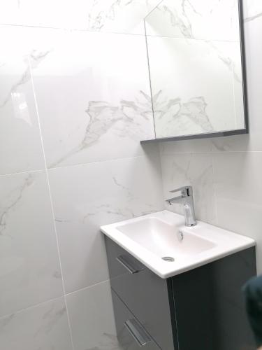a white bathroom with a sink and a mirror at гест хаус паркова 33 in Razgrad