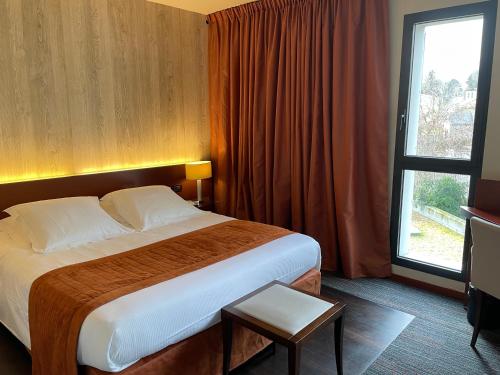 a hotel room with a large bed and a window at Hotel du Casino in Saint-Valéry-en-Caux