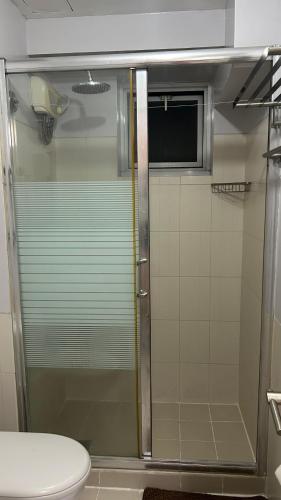 a shower with a glass door in a bathroom at Condo Unit at La Verti Residences in Manila