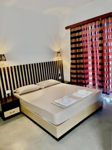 a large bed in a bedroom with a window at Aleks Holiday Rooms in Ksamil