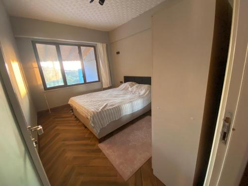 a small bedroom with a bed and a window at Kocaeli başiskele lüks müstakil Havuzlu Villa in Kocaeli