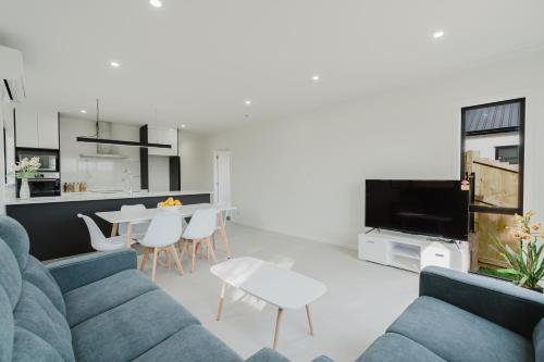 a living room with a couch and a table at Brand New 3Bedrooms House in The Base Te Rapa in Hamilton