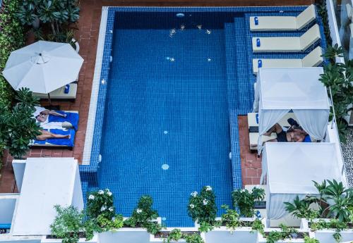 an overhead view of a swimming pool with chairs and umbrellas at Home Chic Hotel in Phnom Penh