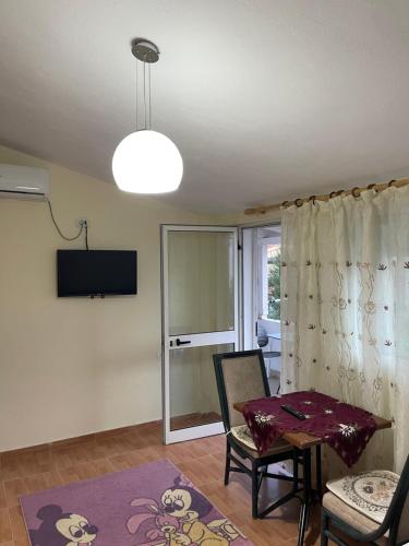 a living room with a table and a tv at Gazi’s Apartament for Rent in Golem