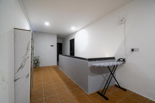 a hallway with white walls and a table in a room at BOSS Hotel in Ipoh