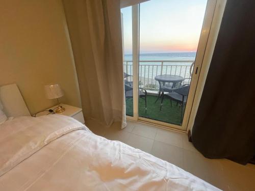 a bedroom with a bed and a view of the ocean at امواج رزيدنس ابراج الشاطئ ثلاث غرف عوائل فقط in King Abdullah Economic City