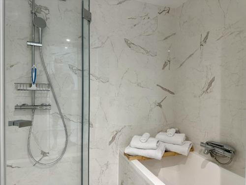 a bathroom with a shower and a bath tub with towels at Seaside View Saint-Laurent in Saint-Laurent-du-Var