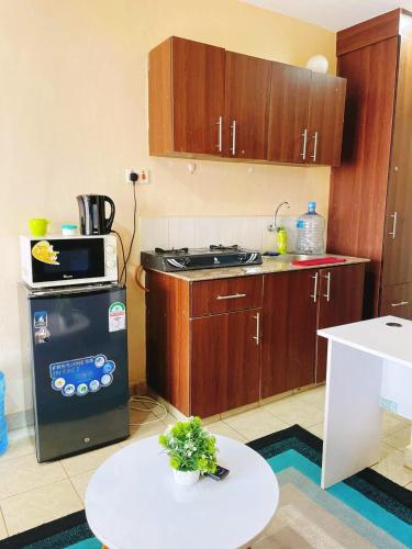 a kitchen with a stove and a table in it at Aheri Homes in Ruaka