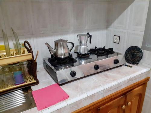 a stove top with two tea pots on it at Dar Al-Amira - Fnideq Beach Apartment in Fnidek